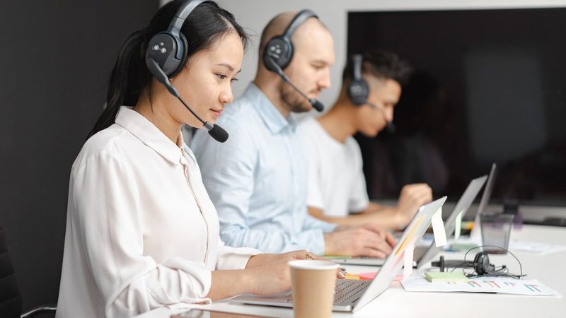 Profissional de atendimento trabalhando no computador, cenário de uso do WhatsApp Business
