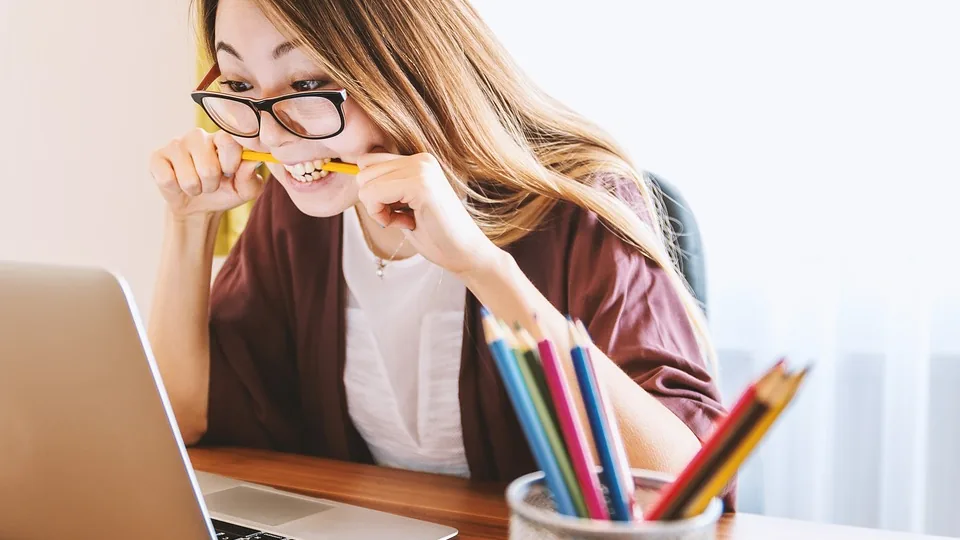 Pessoa usando notebook e fazendo anotações em um ambiente de trabalho