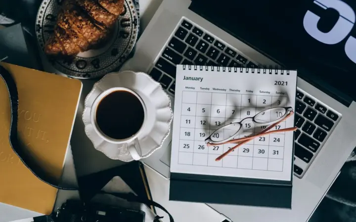 Agenda digital com laptop e calendário sobre uma mesa
