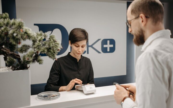 Foto de uma pessoa usando o celular em um balcão de atendimento, ilustrando o WhatsApp Business