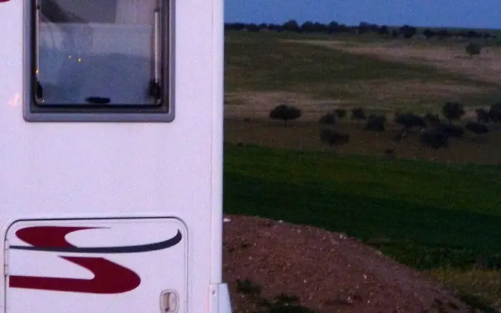 Motorhome estacionado ao entardecer em uma paisagem de viagem