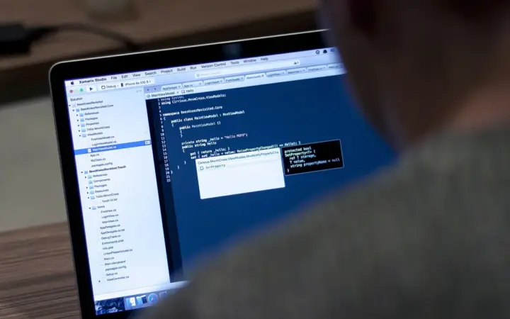 Computador portátil exibindo código em uma tela, usado para ilustrar a configuração de SSH no GitHub