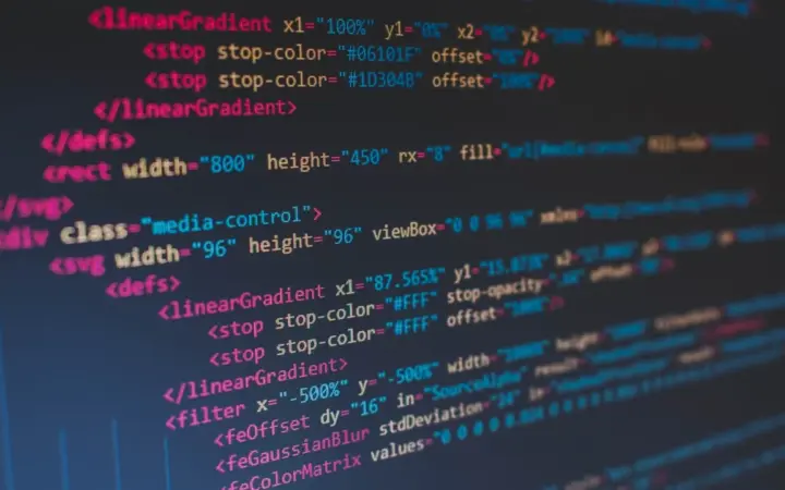 Pessoa programando em um notebook com código na tela