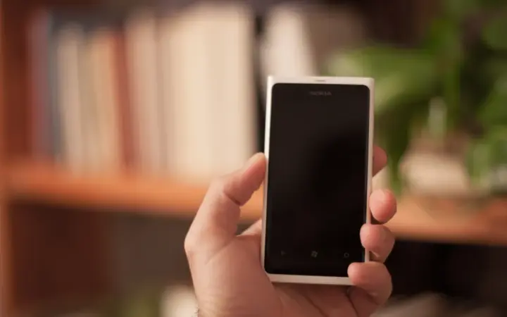 Pessoa segurando um smartphone para iniciar uma conversa pelo WhatsApp