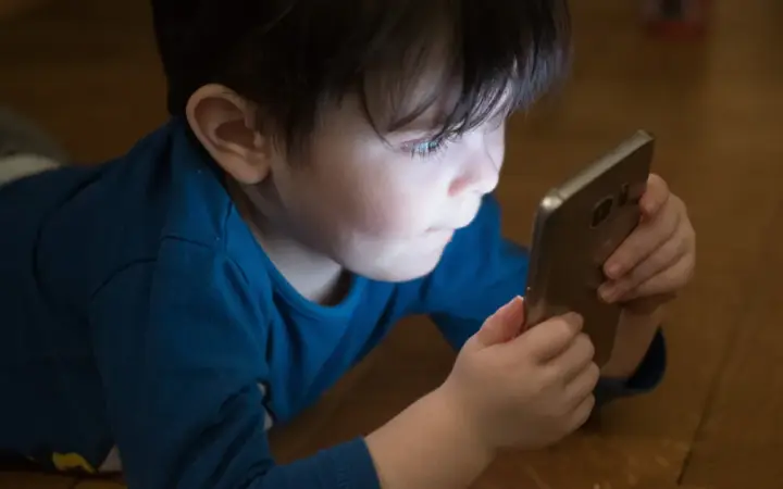 Criança usando smartphone, tema de controle parental no Android