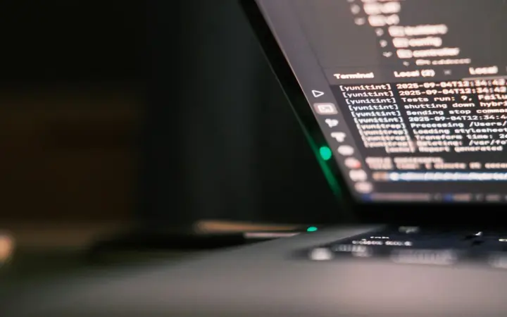 Pessoa programando em um notebook com código na tela