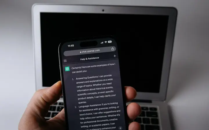 Smartphone ao lado de um laptop em uma mesa de trabalho