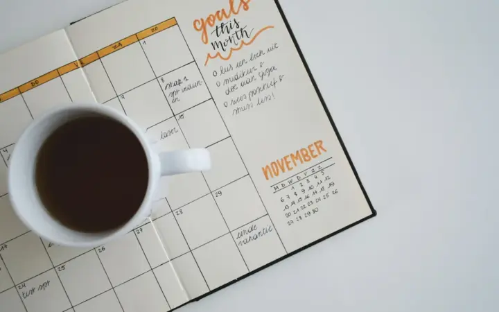 Mesa de trabalho com calendário e computador para ilustrar agendamento de horários