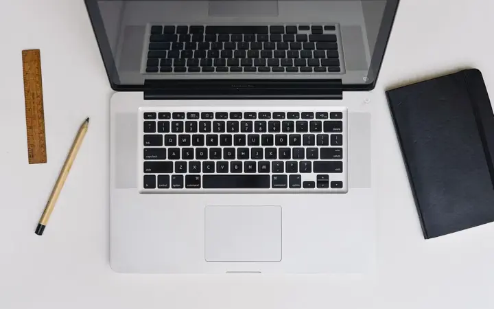Pessoa trabalhando em um laptop sobre uma mesa, representando o uso do Gmail com ferramentas de inteligência artificial.