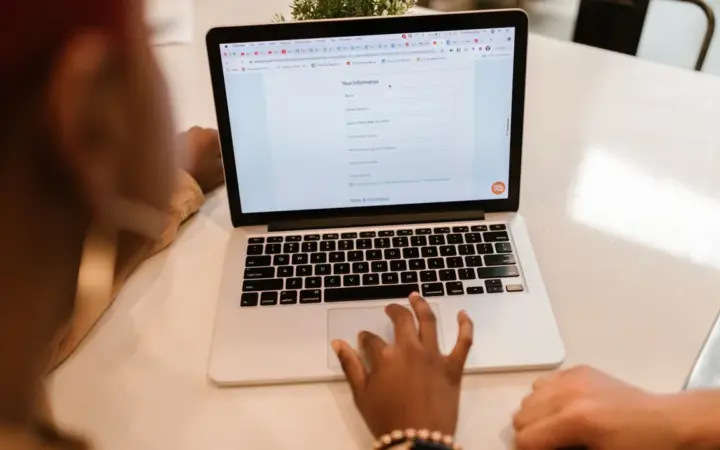 Duas pessoas usando um laptop para preencher um formulário online