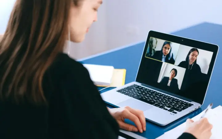 Mulher participando de uma videochamada em um notebook