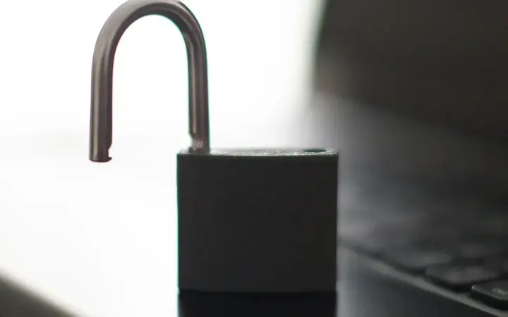 Notebook exibindo um cadeado aberto, imagem usada para explicar chaves de acesso e login sem senha