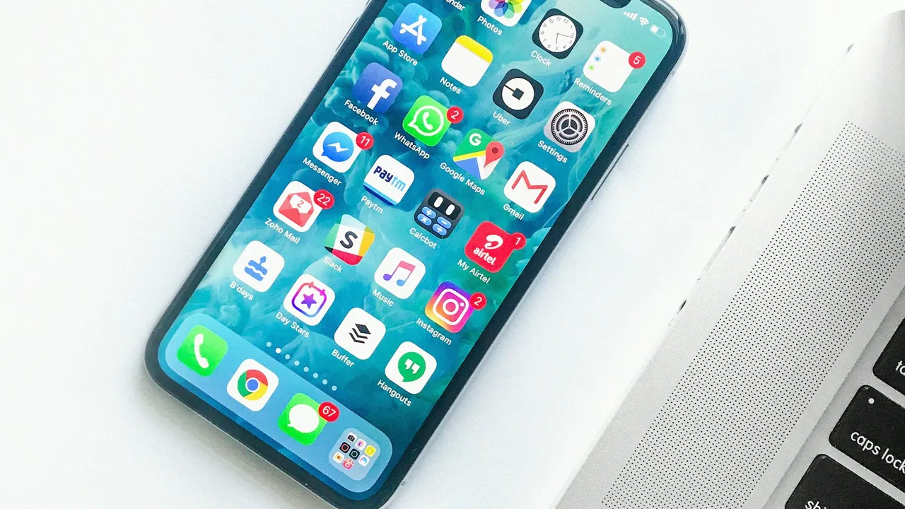 Smartphone apoiado ao lado de um computador, usado para autenticar o acesso com chave de acesso