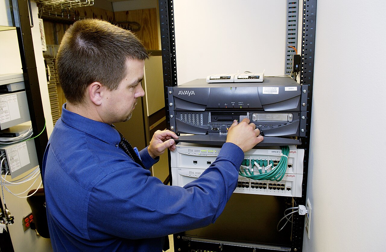 Rack de servidores e técnico trabalhando em uma infraestrutura de rede