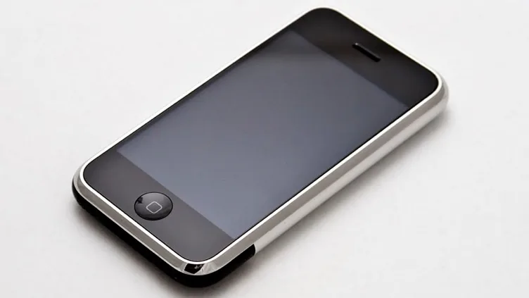 Primeiro modelo de iPhone exibido em uma tela, imagem ilustrativa de celular e notificações