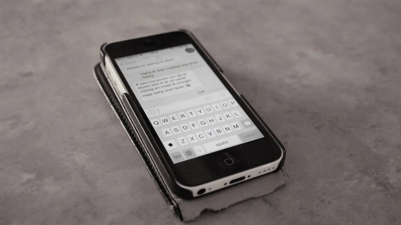 Pessoa usando um smartphone para trocar mensagens, representando atendimento automatizado no WhatsApp