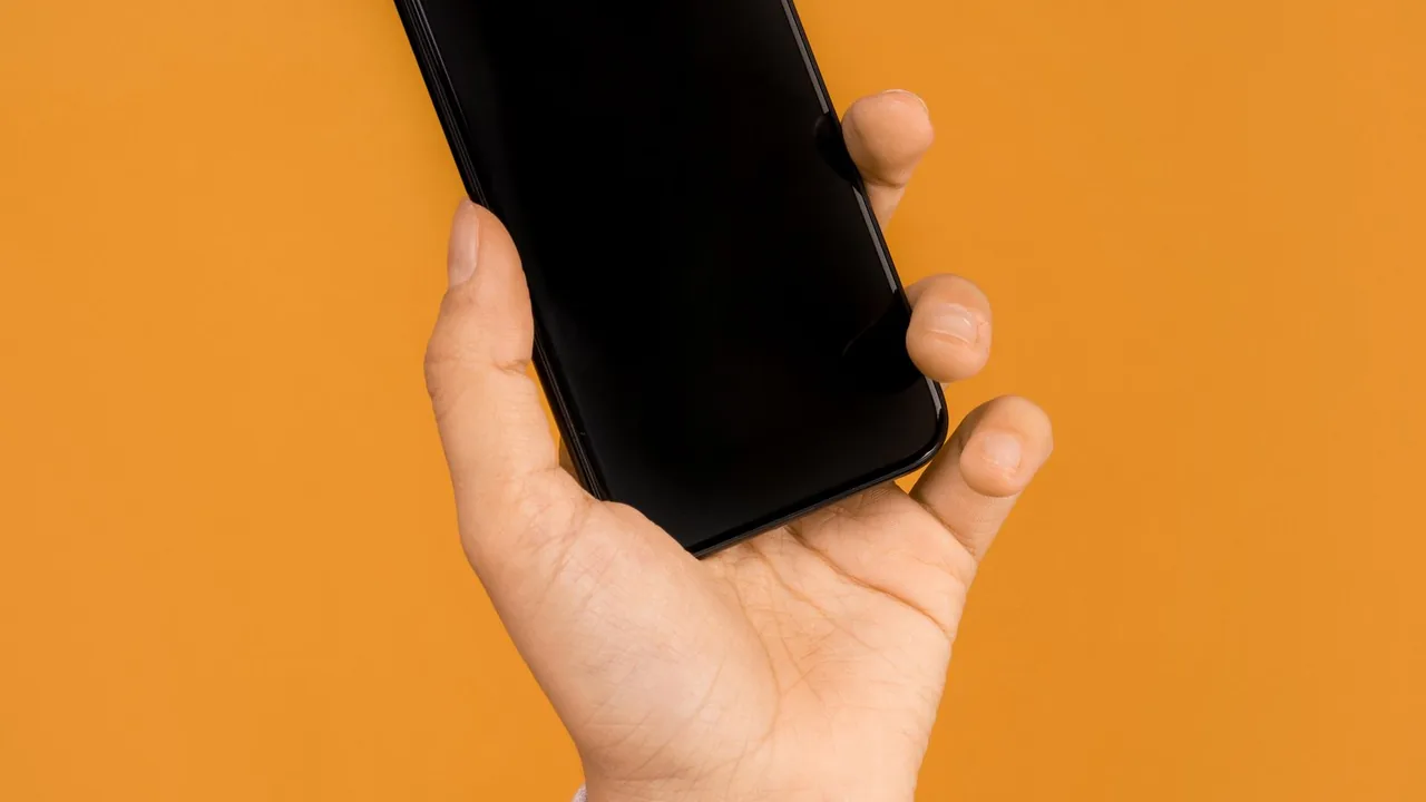 Mãos segurando um smartphone com aplicativo de conversa para atendimento