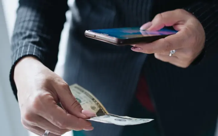 Mulher usando smartphone em um escritório para organizar o atendimento comercial