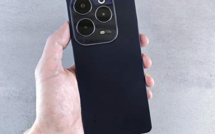 Celular Android sendo segurado pela mão, visto pela traseira