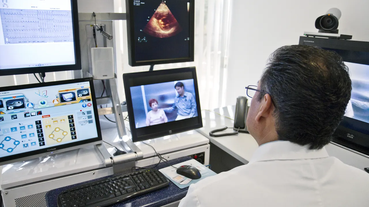 Profissional de saúde diante de monitores em um ambiente de telemedicina.