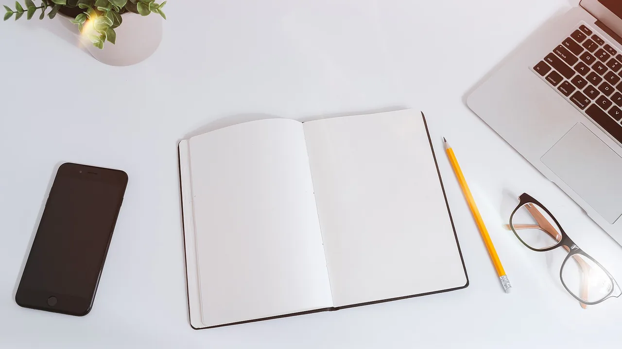 Mesa de trabalho com notebook e caderno, imagem contextual para explicar a organização da caixa de entrada.