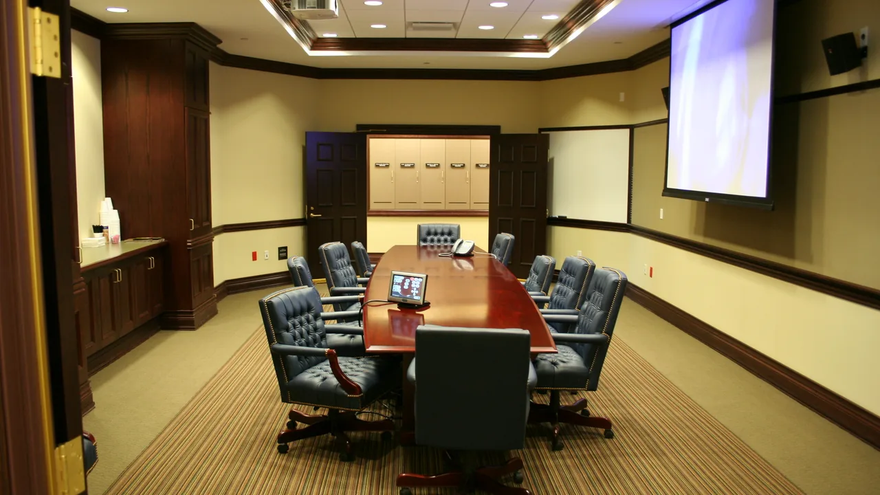 Sala equipada para videoconferência, com câmeras e monitores