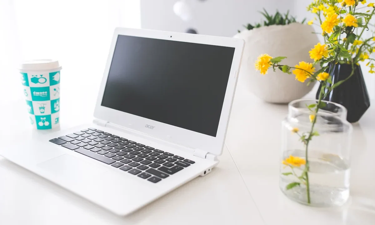 Imagem destacada: laptop em uma mesa de trabalho para ilustrar produtividade no Google Sheets.