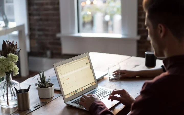 Pessoa trabalhando em um escritório com um notebook, imagem destacada para foco e notificações no Windows 11