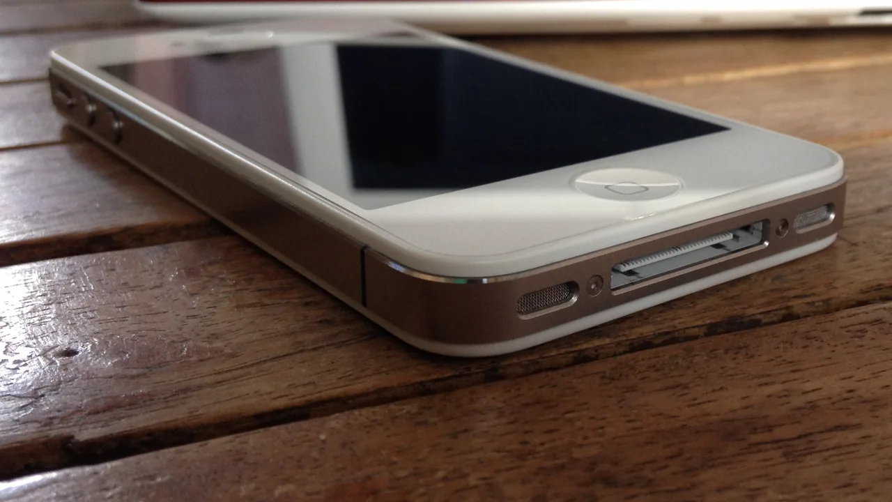 iPhone branco apoiado sobre uma mesa de madeira