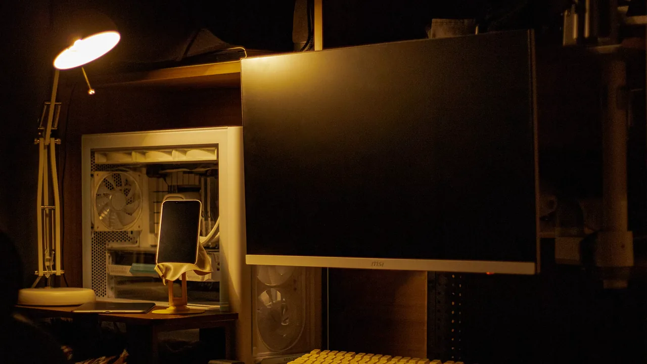 Monitor de computador em uma mesa escura com luz quente