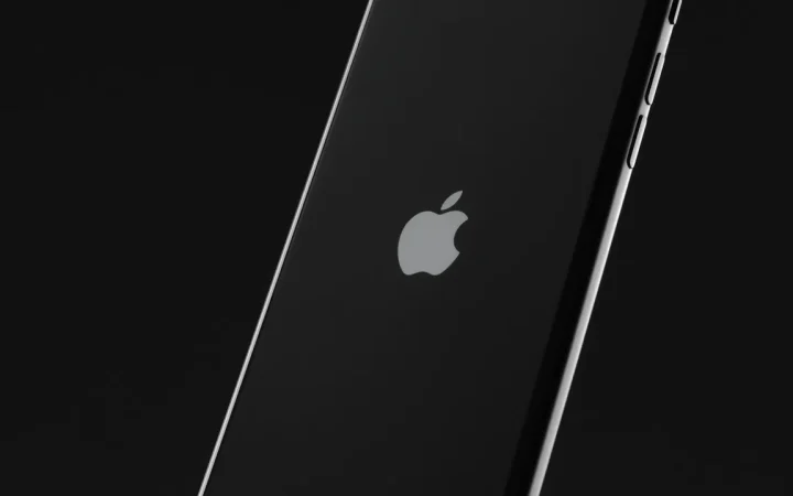 iPhone preto visto de costas sobre fundo escuro, representando economia de bateria