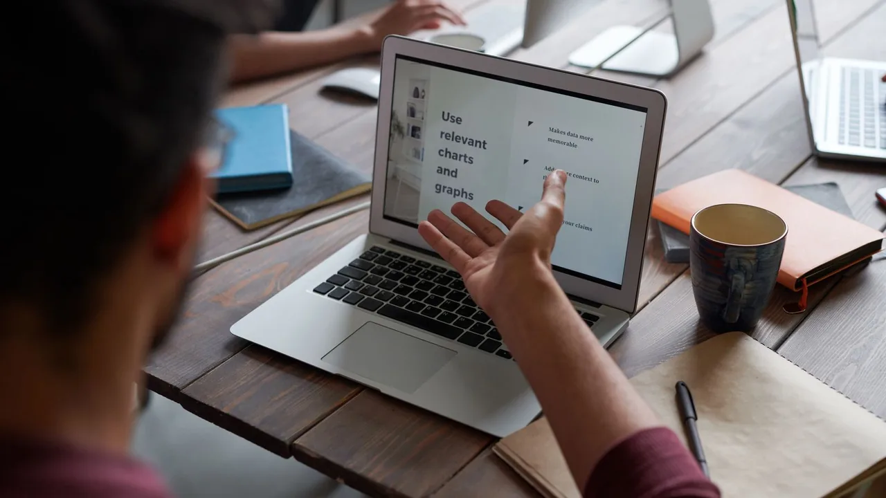 Pessoa mostrando um documento em um notebook durante uma colaboração