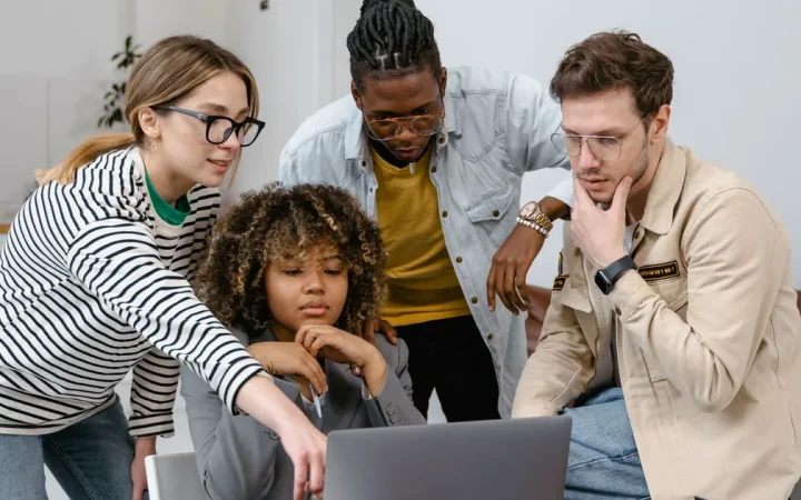 Pessoas reunidas em torno de um notebook para compartilhar um arquivo